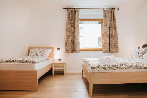 1 Schlafzimmer mit 2 Betten und einem Fenster in der Unterkunft Apartmaji URŠIČ in Kobarid