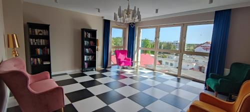 een woonkamer met een geruite vloer en roze stoelen bij Nowoczesny apartament 07 in Sianozety