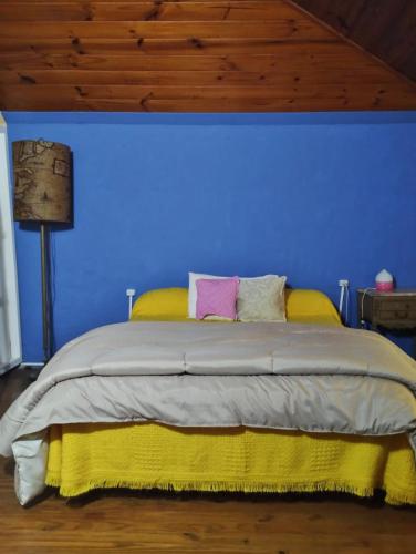 a blue bedroom with a bed with yellow and pink pillows at Isla Pupe in Tigre