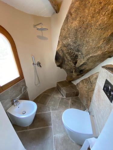 a bathroom with a sink and a toilet and a rock at La Maddalena Exclusive villas in La Maddalena