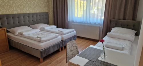 Un dormitorio con 2 camas y una mesa con un jarrón. en Willa Samana Pokoje, en Dziwnówek