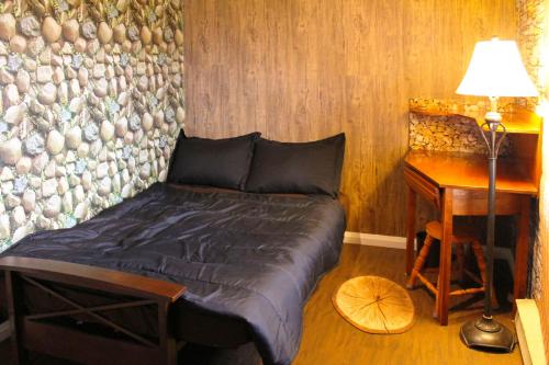 Private 3 bedrooms, Free parking, Private bathroom في Lower Sackville: غرفة نوم مع سرير ومكتب مع مصباح