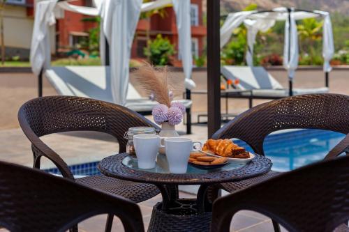 an outdoor table with a tray of food and drinks at Asanjo Villa by VEO - Part of StayVista in Mulshi
