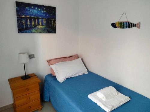 a bedroom with a blue bed and a night stand at Alcalá Center Playa in Alcalá