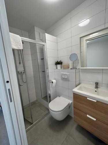 a bathroom with a toilet and a shower and a sink at Luni in Zadar