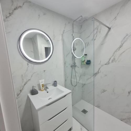 a white bathroom with a sink and a mirror at Apartament Lux in Vinarós