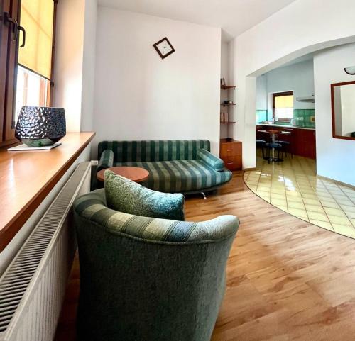 a living room with two green couches and a table at Willa Julia in Karwia