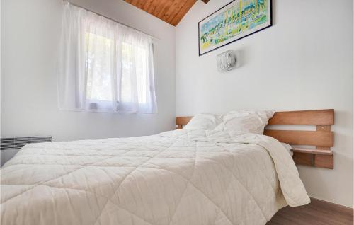 ein weißes Schlafzimmer mit einem großen Bett und einem Fenster in der Unterkunft Amazing Home In La Faute-sur-mer With Heated Swimming Pool in La Faute-sur-Mer