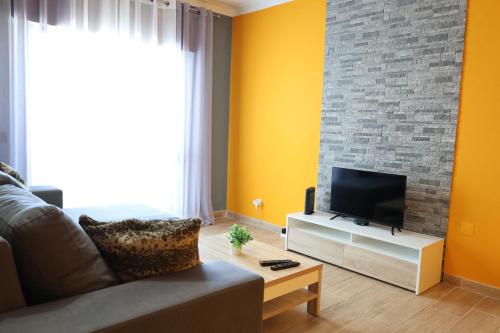 un soggiorno con divano e TV a schermo piatto di Apartamento - Férias Felizes Portimão a Portimão