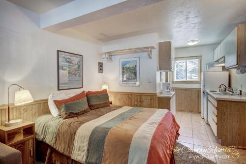 um quarto com uma cama grande e uma cozinha em Affordable and Cozy Condo Steps from Main Street with Spacious Lobby, Hot Tubs PM3B em Breckenridge