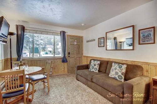 uma sala de estar com um sofá e uma mesa em Affordable and Cozy Condo Steps from Main Street with Spacious Lobby, Hot Tubs PM3B em Breckenridge