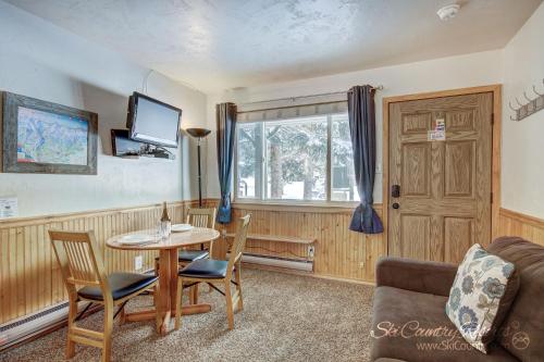 uma sala de estar com uma mesa e cadeiras e uma janela em Affordable and Cozy Condo Steps from Main Street with Spacious Lobby, Hot Tubs PM3B em Breckenridge