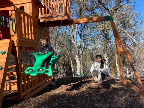a man and a woman sitting in a swing at Modern House on 5 acr in Sequoia National Forest in Panorama Heights