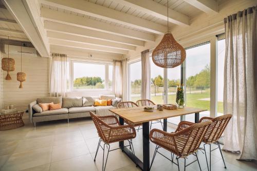 sala de estar con mesa, sillas y sofá en Morze2 - domy całoroczne nad morzem, en Lubiatowo