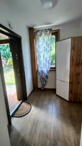 an empty room with a refrigerator and a window at Apartament Pod Czereśnią in Suwałki