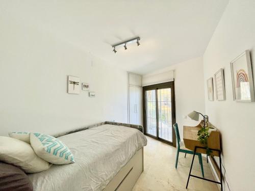 1 dormitorio blanco con 1 cama y 1 silla en Marbella del Mar III Seafront by EaW Homes en Marbella