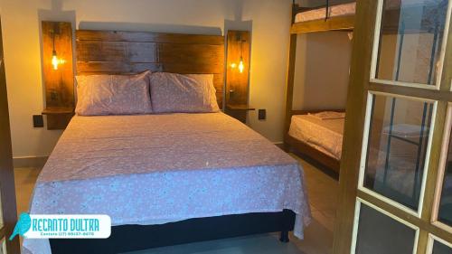 a bedroom with a bed with a wooden headboard at Recanto Dutra in Olímpia