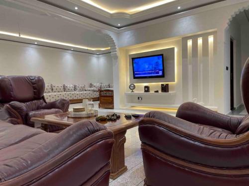salon ze skórzanymi meblami i telewizorem z płaskim ekranem w obiekcie Luxury apartment w Fezie