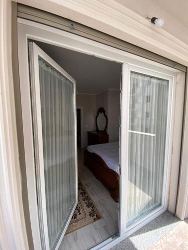 a sliding glass door leading to a bedroom with a bed at Apartment 2+1 Center of Shkoder in Shkodër