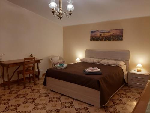 een slaapkamer met een bed, een tafel en een bureau bij Country House Poggio della Roverella in Morlupo
