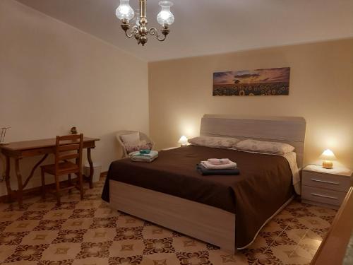 ein Schlafzimmer mit einem Bett, einem Tisch und einem Schreibtisch in der Unterkunft Poggio della Roverella Country House in Morlupo