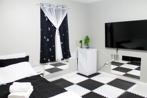 Private 3 bedrooms, Free parking, Private bathroom في Lower Sackville: غرفة نوم مع تلفزيون وأرضية سوداء وبيضاء