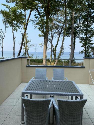stół i krzesła na patio z widokiem na ocean w obiekcie Apartament Amalia z widokiem na morze w Rewalu