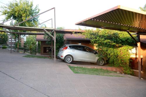 a small silver car parked in front of a house at Complejo Los Cipreses in Villa Carlos Paz