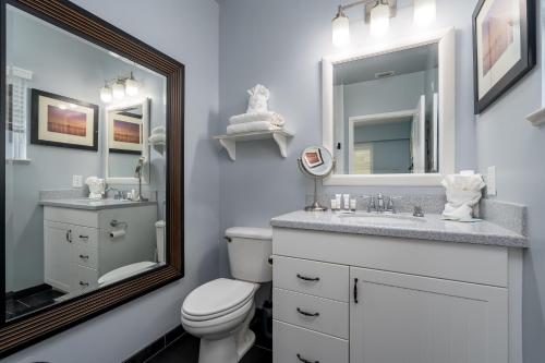 a bathroom with a toilet and a sink and a mirror at Best View and rooms of Harbour House at the INN in Fort Myers Beach