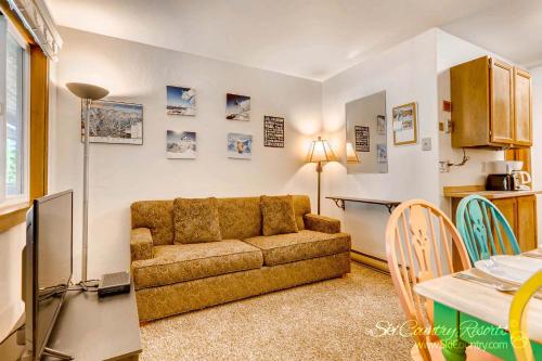 uma sala de estar com um sofá e uma mesa em Economical, Cozy Condo Near Main St Access to Spacious Lobby, Hot Tubs PM5B em Breckenridge