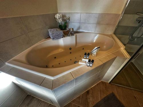 een badkamer met een ligbad en een wastafel bij B&B de Muldermolen in Schinnen
