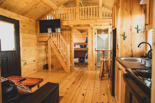 um chalé de madeira com uma cozinha e uma sala de estar em The Big Texan - Cabins and Wagons em Amarillo