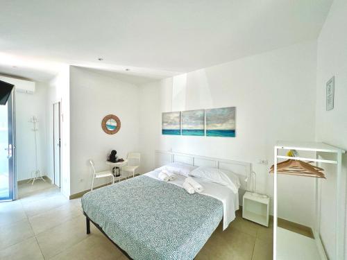 a white bedroom with a bed and a table at Le 4 Stagioni rooms in Francavilla al Mare