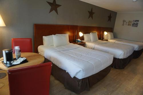 Habitación de hotel con 2 camas y mesa en Harvest Drive Family Inn - Renovated Rooms, en Gordonville