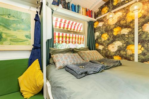 een slaapkamer met een bed in een kamer met een schilderij bij Tiny House in Kampen