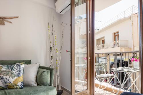 sala de estar con sofá verde y puerta de cristal en Anchel maison, en Rethymno