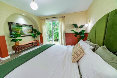 Un dormitorio con una gran cama blanca y una ventana en The Springs Motel en New Ashford