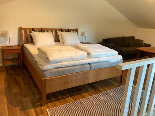 a bedroom with a large bed and a couch at Fin lägenhet mitt på Bjärehalvön in Båstad