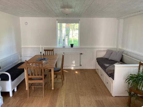 a room with a table and a bed and a dining room at Fin lägenhet mitt på Bjärehalvön in Båstad