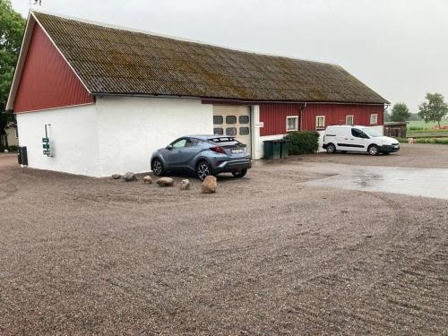a car parked in front of a red and white building at Fin lägenhet mitt på Bjärehalvön in Båstad