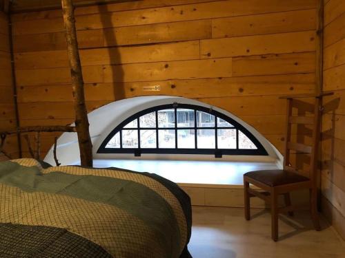 Zimmer mit Fenster in einer Holzhütte in der Unterkunft Nostalgisch overnachten in hooimijt 