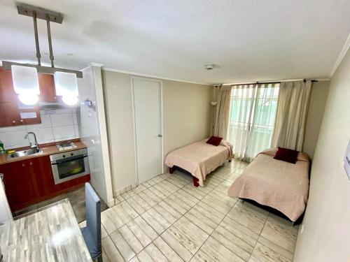 - une petite cuisine avec 2 lits dans une chambre dans l'établissement Acuña & Donoso Apartamentos Centro, à Santiago