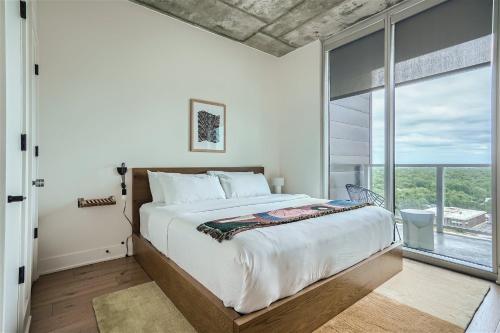 a bedroom with a large bed and a large window at Spacious 1 BR condo - Amazing views - Pool - Kitchen in Austin