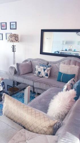 a living room with two couches and a mirror at Appartement très chaleureux à 3 minutes de l'océan in Libreville