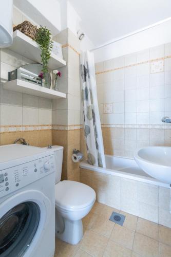a bathroom with a washing machine and a sink at Anesis Seaview Apartment 2 in Neos Marmaras