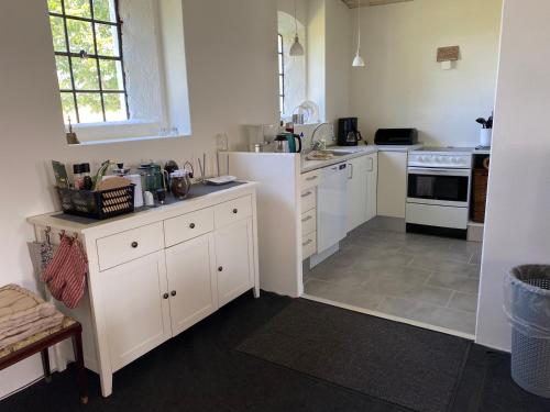 a kitchen with white cabinets and a stove at Bregnedalsgaard Bondegårdsferie in Hobro