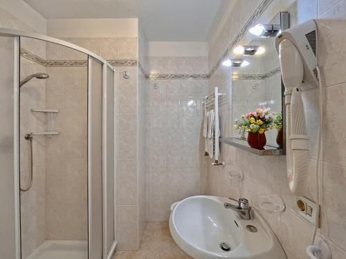 a white bathroom with a sink and a shower at Casa Letizia in Livigno