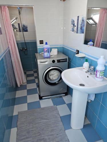 a bathroom with a washing machine and a sink at Dar Khadija in Asilah
