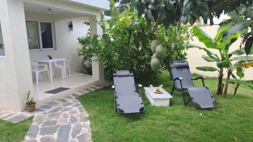 a backyard with two chairs and a table and a table and chairs at Casa taina in Jarabacoa