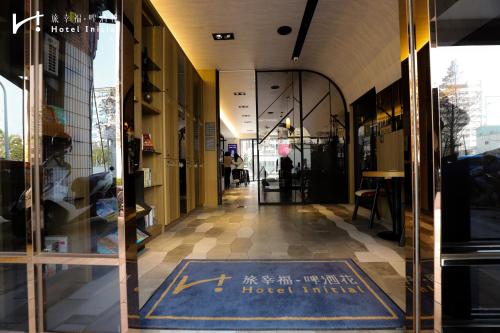 an entrance to a building with a sign on the door at Hotel Initial-Beer in Tainan